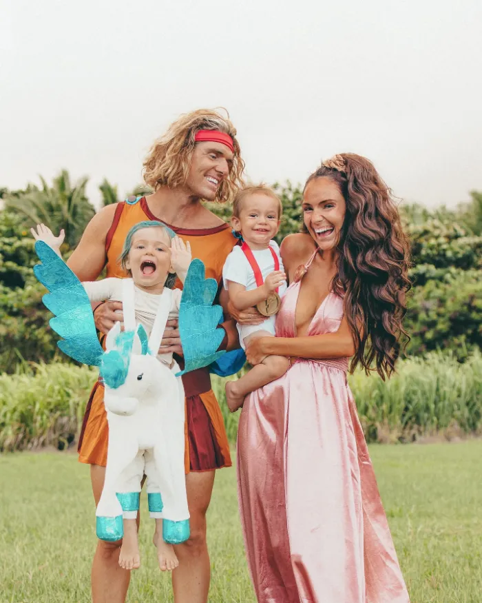 Family dressed as Hercules characters with a child riding a Pegasus costume.